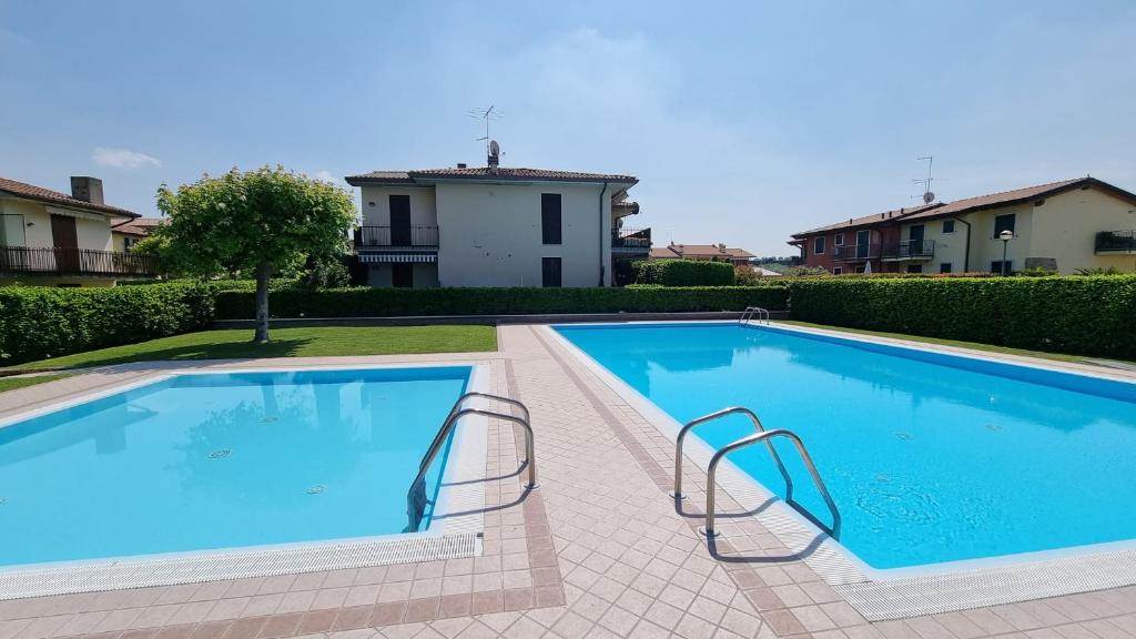 une grande piscine bleue dans une cour dans l'établissement Sole del Garda, à Lazise