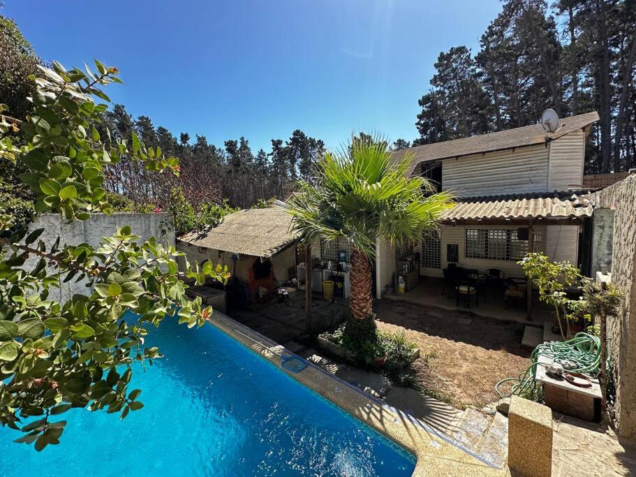 a house with a swimming pool in front of a house at Hermosa casa en Algarrobo in San Antonio