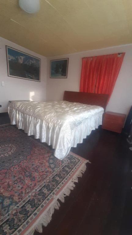 1 dormitorio con cama y cortina roja en B&b Relax / Olga&Claudio, en Cassacco