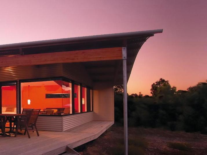 a house with a deck with a table and chairs at Hilltop Studios in Margaret River Town