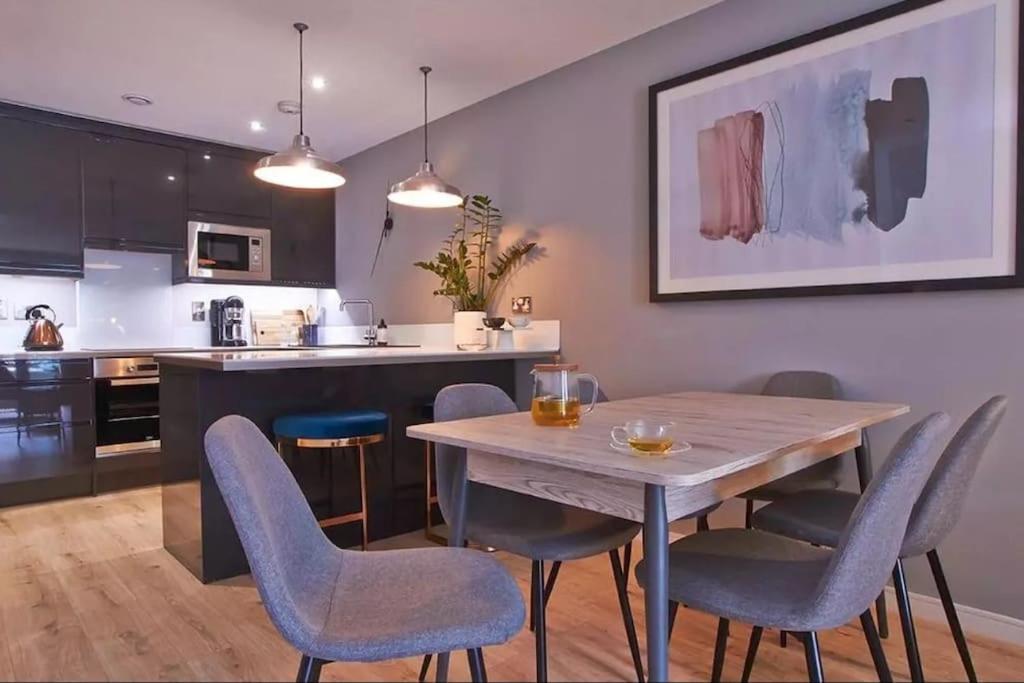 a kitchen and dining room with a wooden table and chairs at Kings Cross Walking Distance Luxury Private Garden House in London