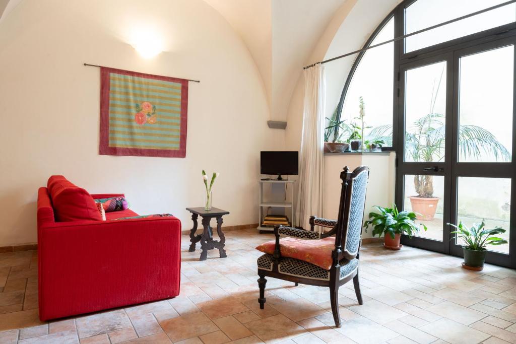 a living room with a red couch and a chair at Characteristic apartment in the center of Florence in Florence