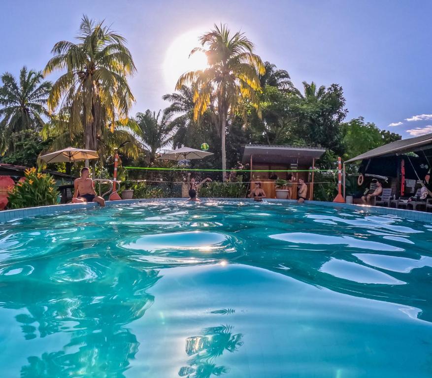 einen Pool in einem Resort mit Palmen im Hintergrund in der Unterkunft Hostel Casa de las Palmas Tours in Leticia