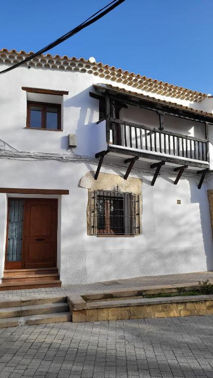 a white house with two windows and a balcony at La Casona de Roser in Cardenete
