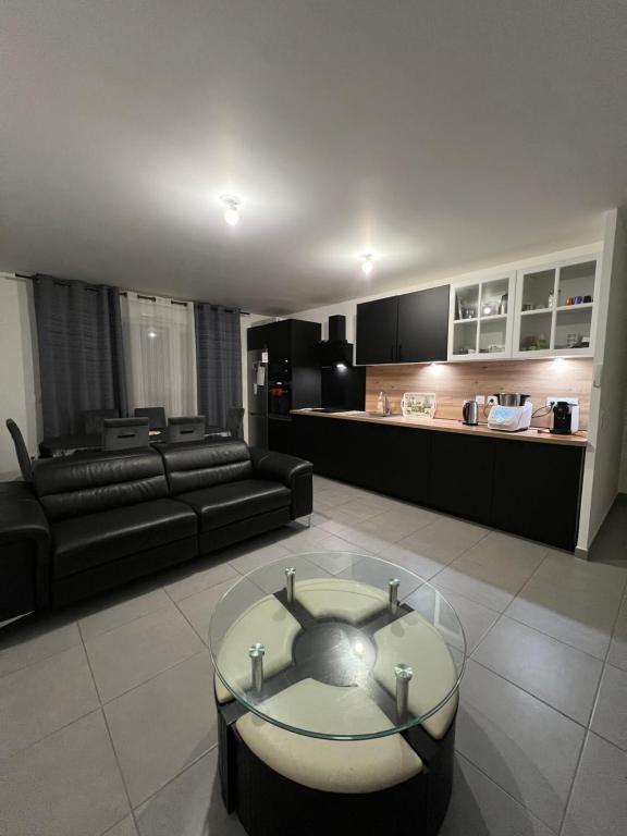 een woonkamer met een bank en een glazen tafel bij Dugny Airways - Le Bourget in Dugny