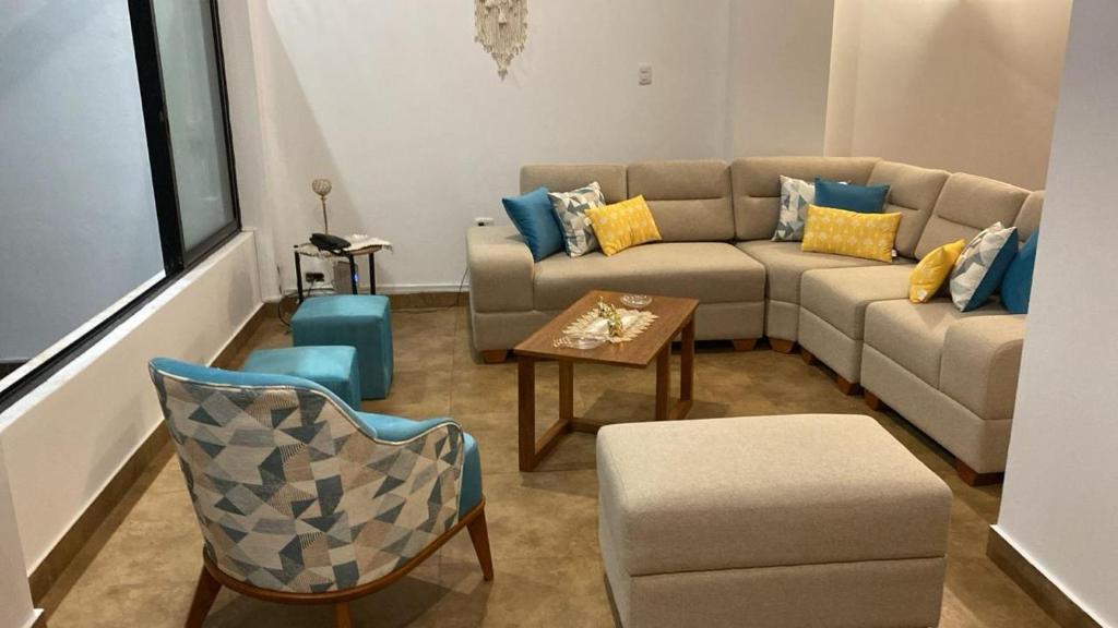 uma sala de estar com um sofá, uma mesa e cadeiras em Casa de Playa moderna em Lima