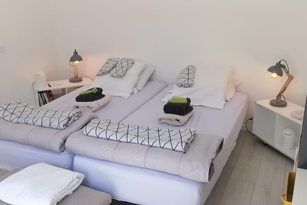 Habitación con 3 camas con sábanas y almohadas blancas. en Logement+parking proche métro - total autonome, en Villejuif