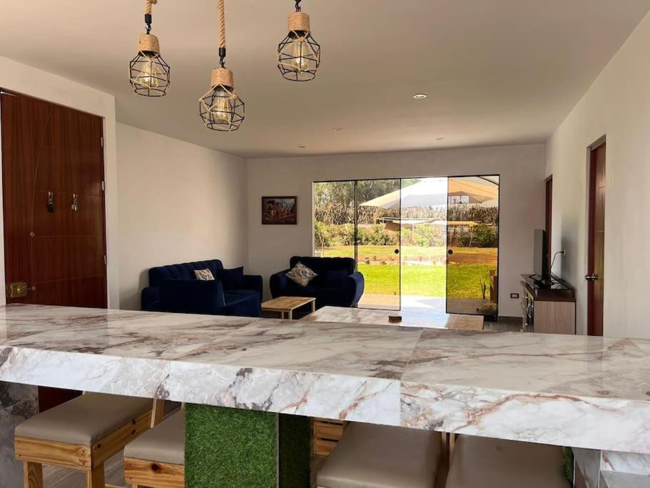 uma cozinha com uma grande bancada em mármore numa sala de estar em Casa de Campo en Cañete em Imperial