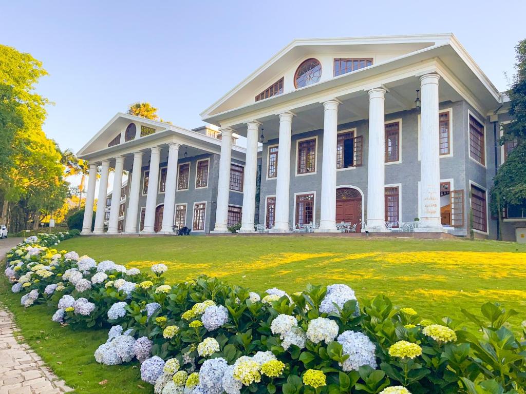 een groot gebouw met bloemen ervoor bij Aroso Paço Hotel in Pedra Azul