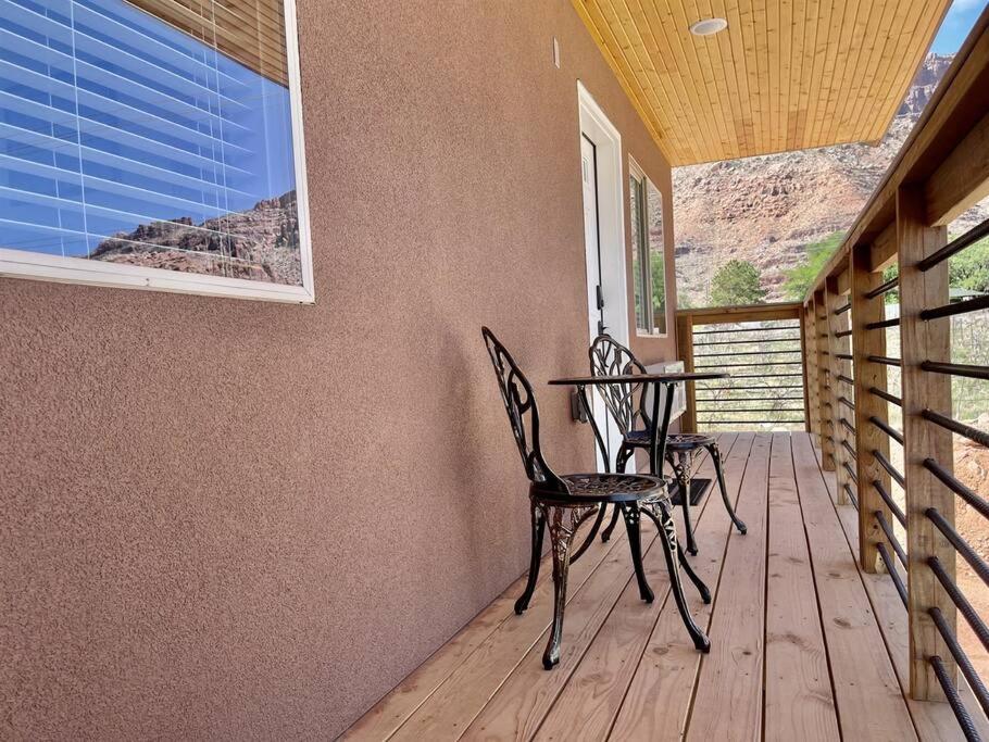 a porch with two chairs and a table on a deck at Angel Rock Rentals of Moab Unit 11 in Moab