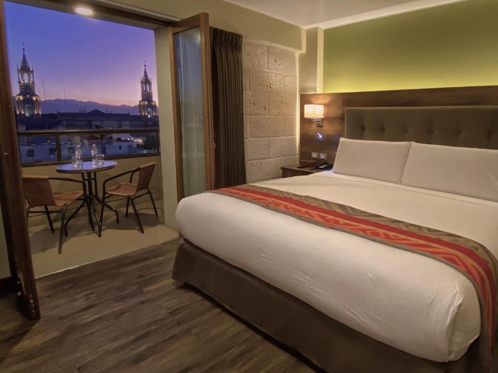 a hotel room with a bed and a view of the city at ARIQUEPAY HOTEL in Arequipa