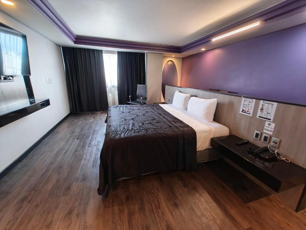 Habitación de hotel con cama grande y suelo de madera. en Hotel Max, en Ciudad de México