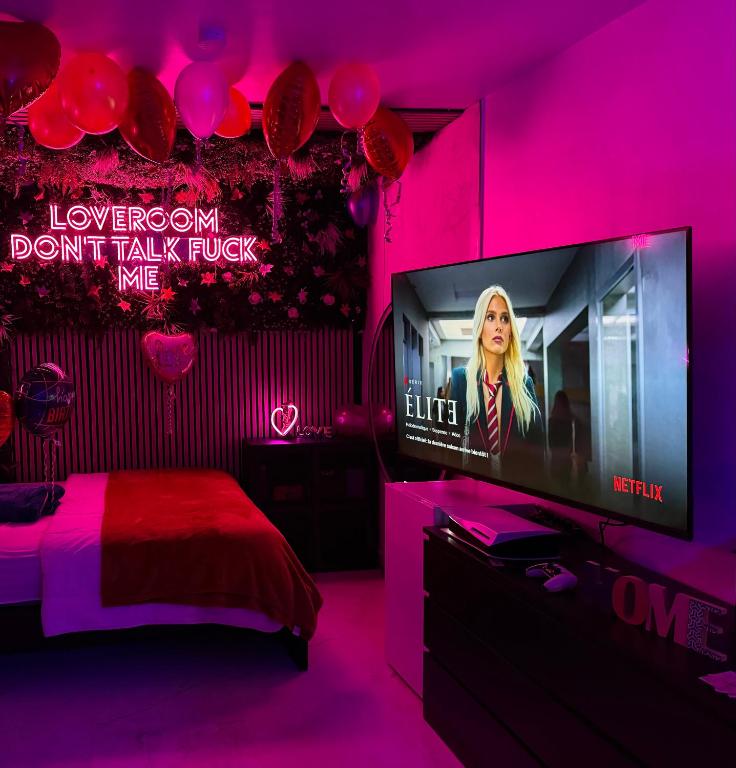 ein Schlafzimmer mit einem rosa Zimmer mit einem Flachbild-TV in der Unterkunft Your Love & your Room in Choisy-le-Roi