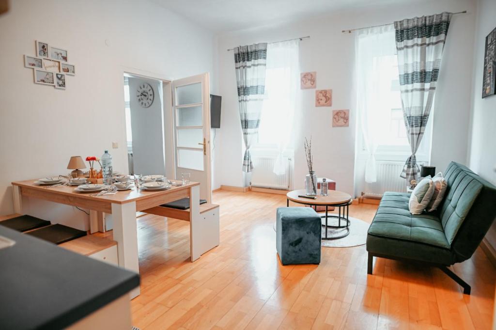 een woonkamer met een tafel en een groene stoel bij Raimond Apartment Top 27 in Wenen