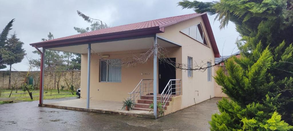 a small house with a porch at Pink Quest House in Lankaran