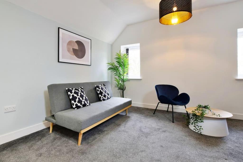 una sala de estar con un sofá y una silla en FREE PARKING - 1 BR Salford Royal sleeps 4, en Mánchester