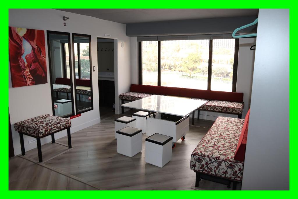 um quarto com uma mesa, cadeiras e janelas em LVStripHouse JC406 - Modern Superior Studio Condo - Sleeps 6 em Las Vegas