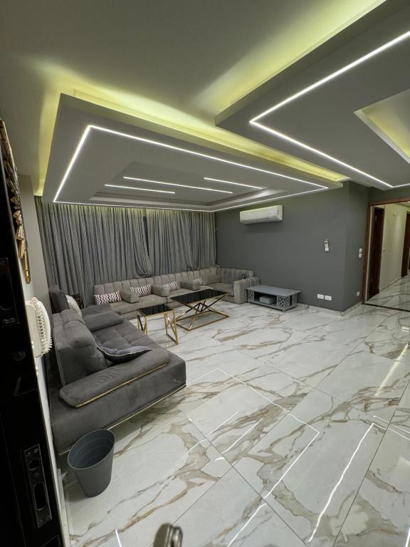 sala de estar con sofás y suelo de mármol en Bright apartment ( شقة واسعة من 3 غرف ), en El Cairo
