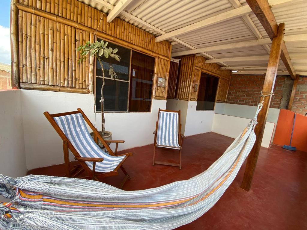 - une terrasse couverte avec 2 fauteuils à bascule et un hamac dans l'établissement Hospedaje Guadalupe Inn, à Máncora