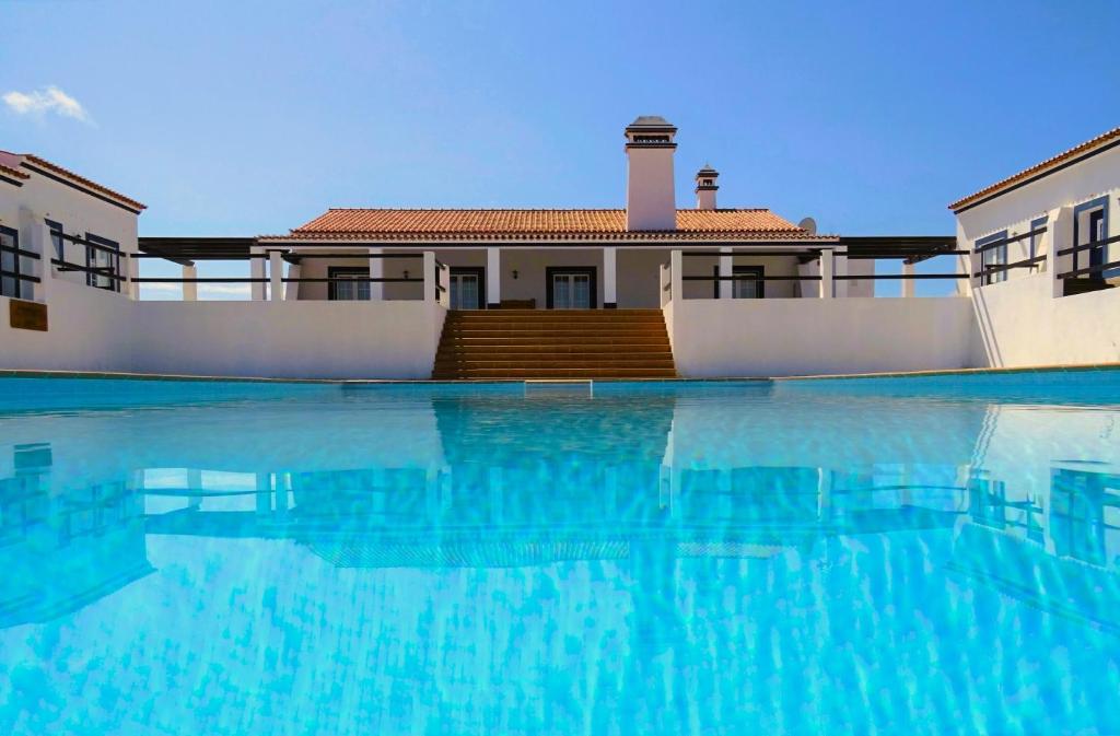 a house with a swimming pool in front of a house at Monte do Alento - Castro da Cola in Alcaria