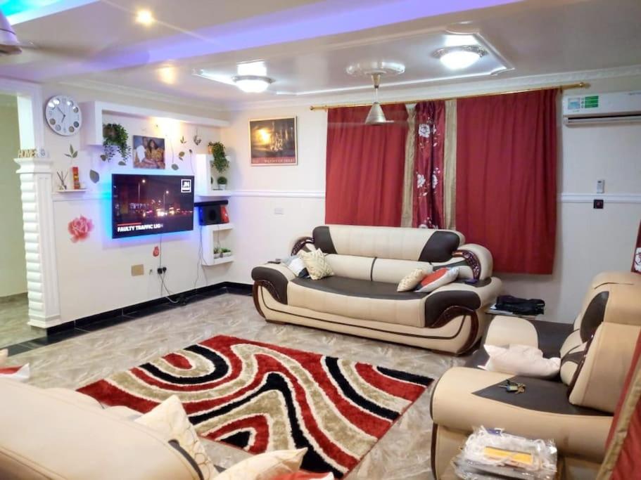 ein Wohnzimmer mit Sofas und einem Flachbild-TV in der Unterkunft A world of your Own in Dodowa