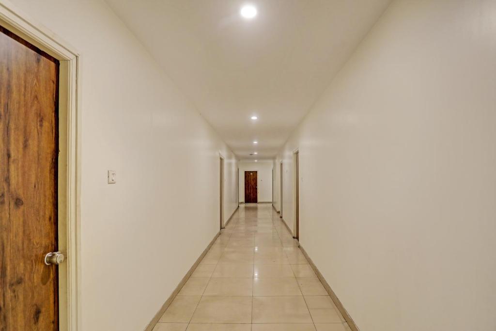 einen leeren Flur mit weißen Wänden und einem Hallwayngth in der Unterkunft Hotel Ramoji in Surūrnagar