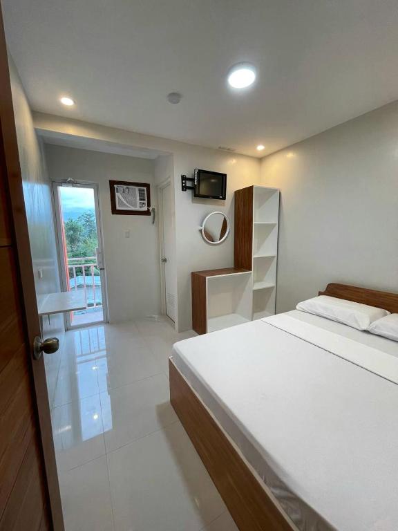 una camera con letto bianco e balcone di Moalboal-Aballe Pension house a Moalboal