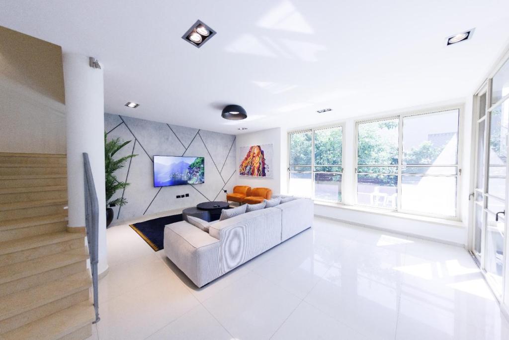 a living room with a couch and a tv at Five Stars Villa09 in Hod HaSharon
