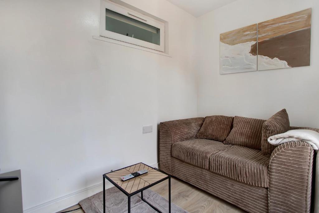 a living room with a couch and a table at Cozy 1-Bed Apartment Close to Lcy & Excel in London