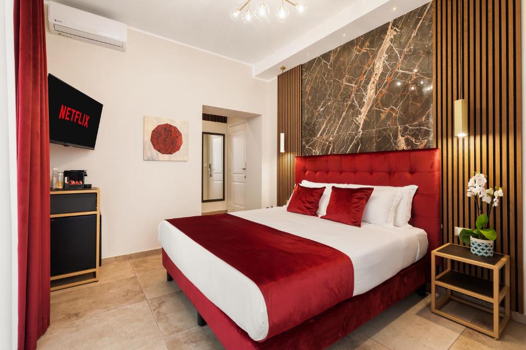 een slaapkamer met een groot bed met een rood hoofdeinde bij AlbaDea Déco&Jacuzzi in Rome