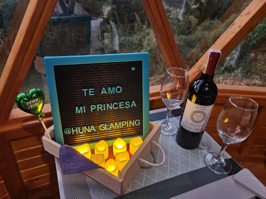 a bottle of wine and a box of chocolates at Huna Glamping in Guatavita
