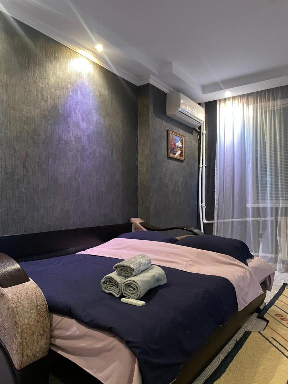 Уютный апартамент في أكتوبي: غرفة نوم عليها سرير وفوط