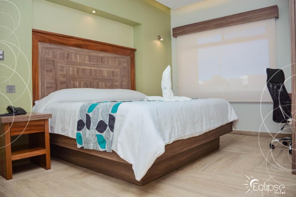 um quarto com uma cama, uma secretária e uma janela em HOTEL ECLIPSE TOLUCA em Toluca
