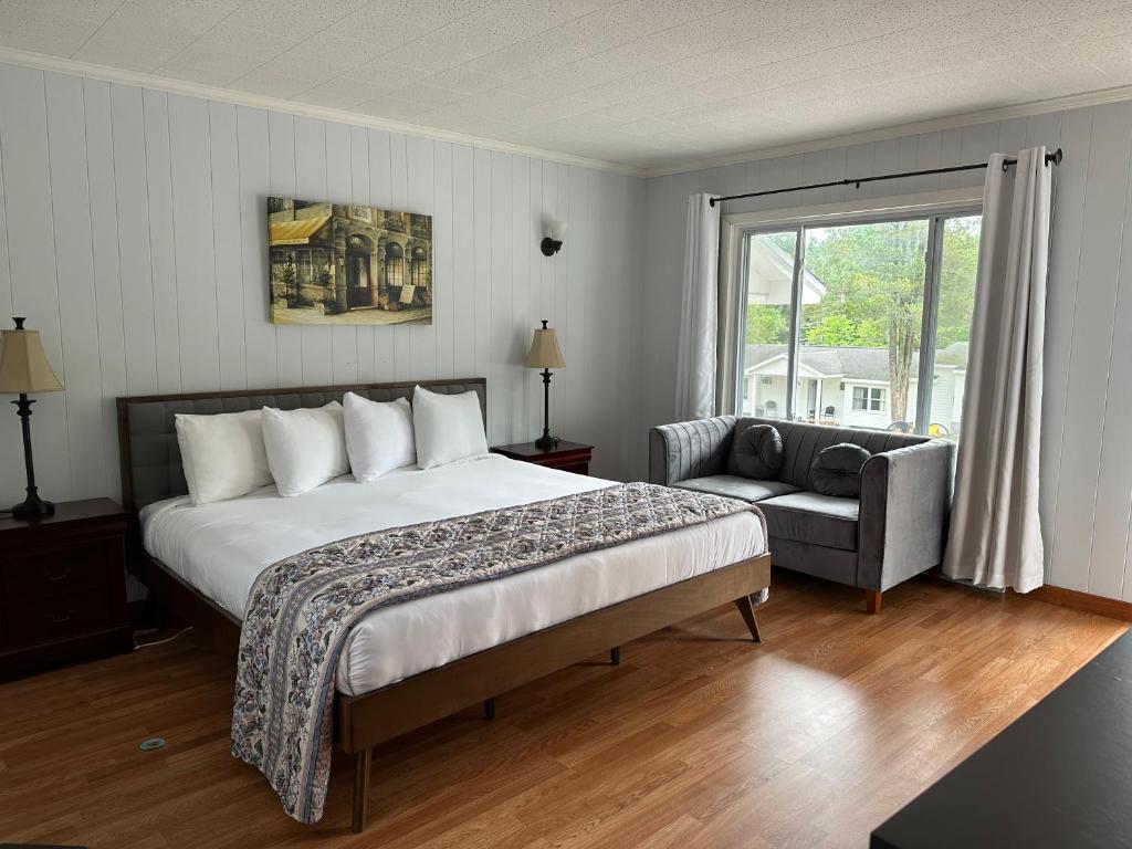 1 dormitorio con cama, sofá y ventana en The Villas on Lake George, en Diamond Point