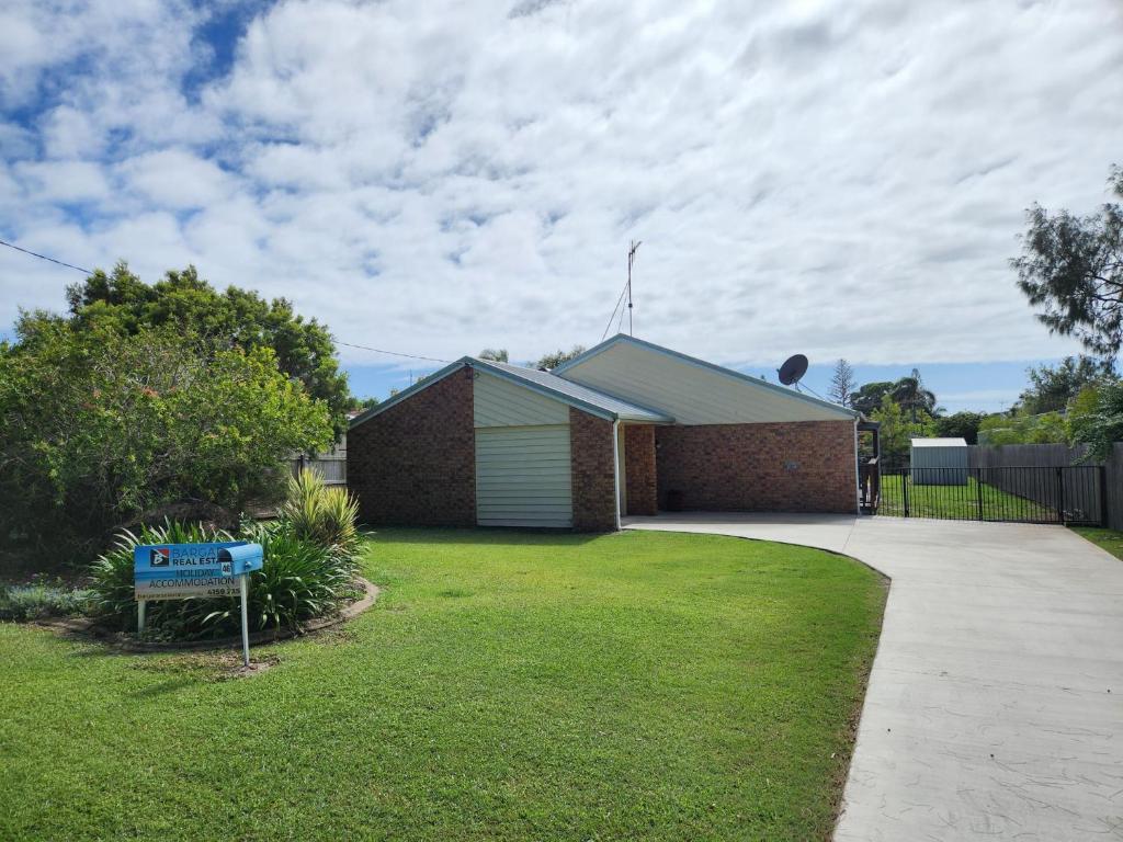 a house with a sign in the front yard at 46 Holland Street Bargara in Bargara