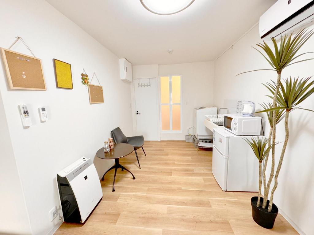 Camera bianca con tavolo e cucina di 道頓堀House ad Osaka