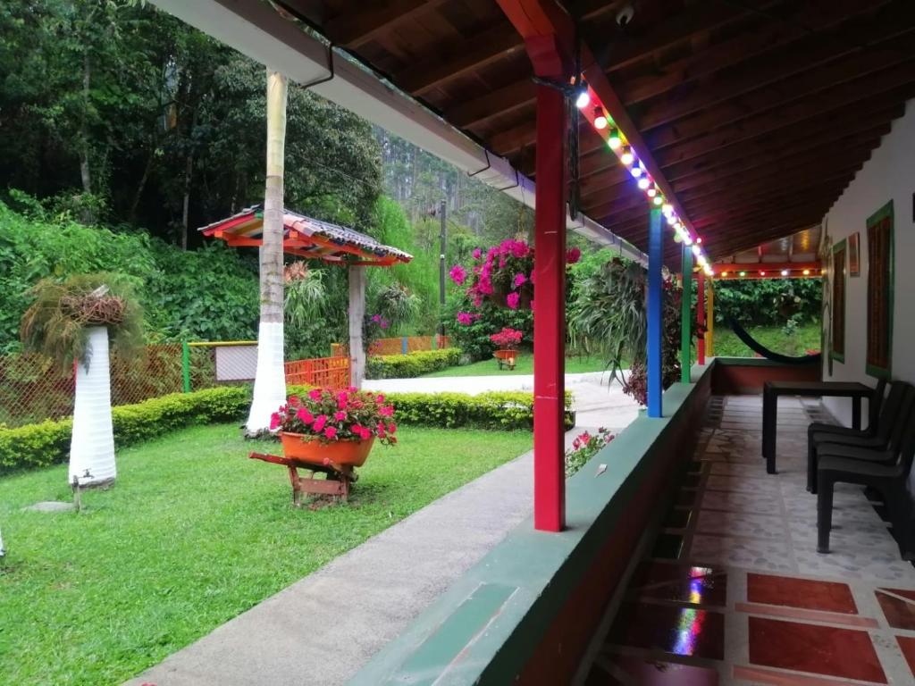 eine Veranda eines Hauses mit einem Garten mit Blumen in der Unterkunft Casa de campo Jardín in Jardin