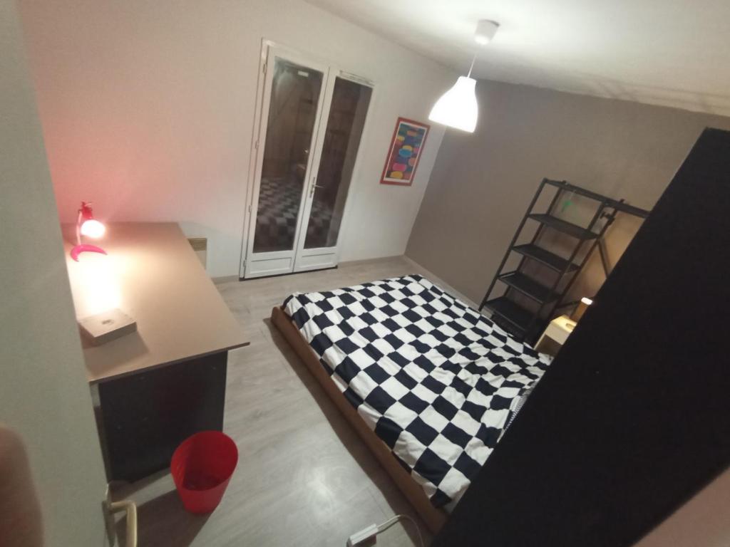 una piccola camera con letto a scacchi di Chambre Calme meublé proche aéroport rocade a Pessac