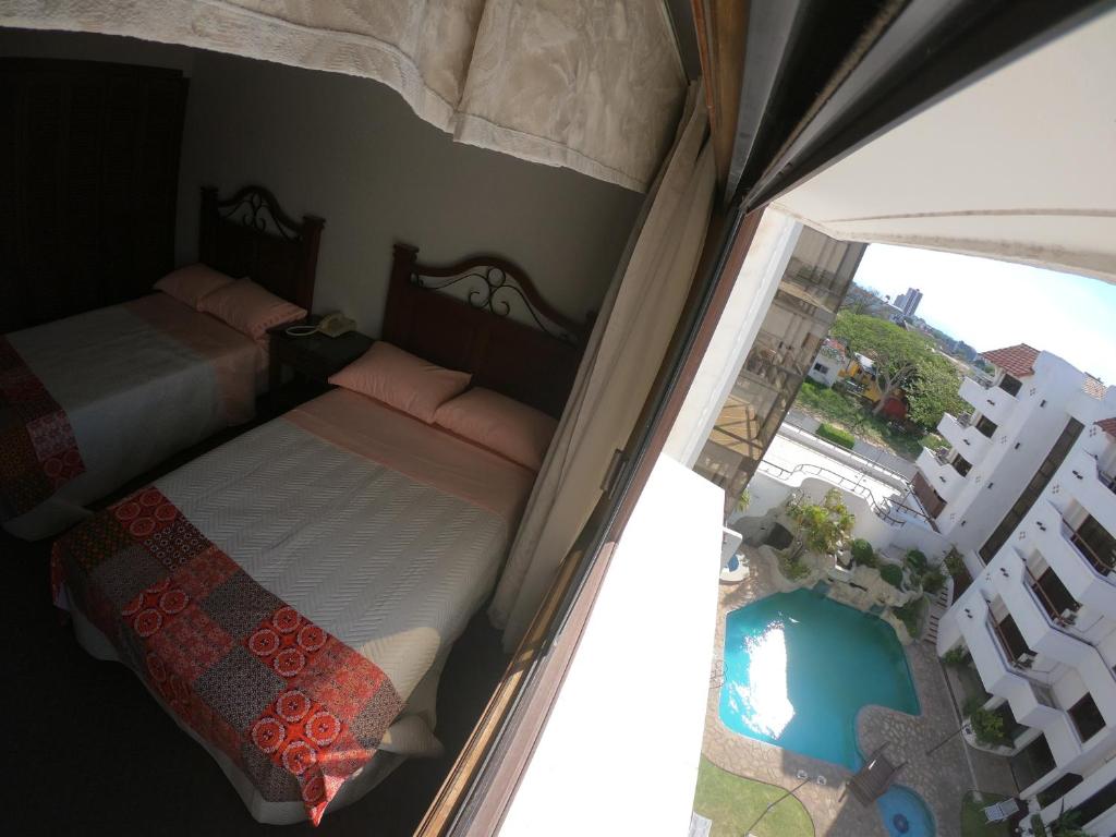 a bedroom with two beds and a balcony with a pool at Suite 5 Estrellas in Santa Cruz de la Sierra