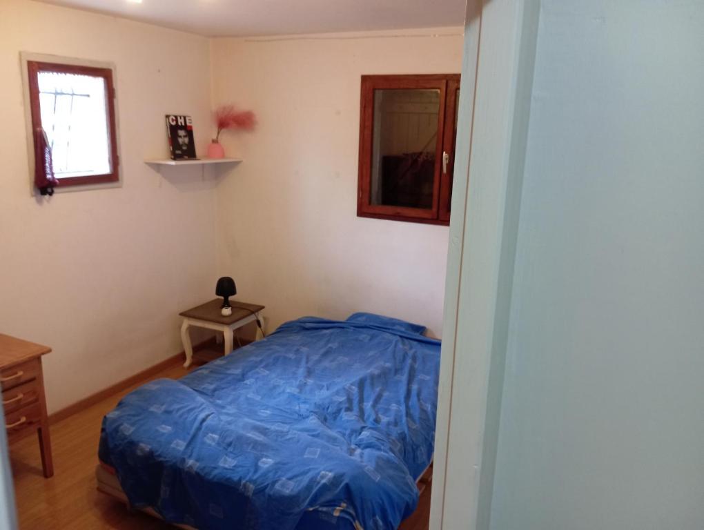 ein Schlafzimmer mit einem Bett mit einer blauen Bettdecke in der Unterkunft chambre bordeaux 33600 Pessac aéroport rocade 12 5 km in Pessac