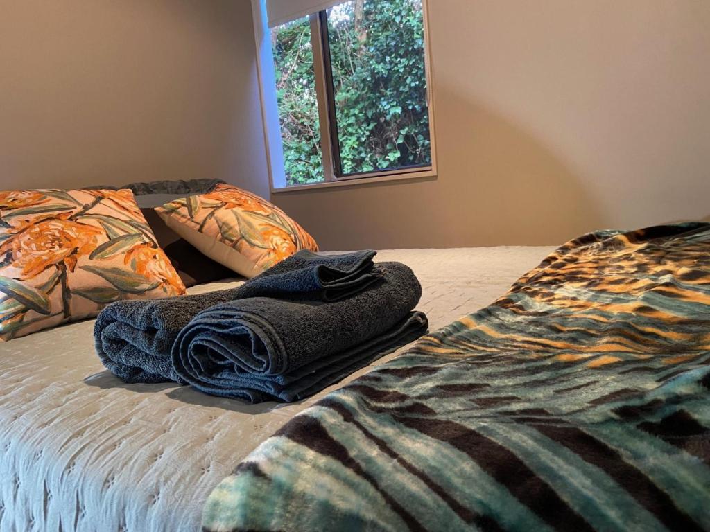 Una cama con un montón de toallas. en Homestay free breakfast Close Motorway, en Auckland
