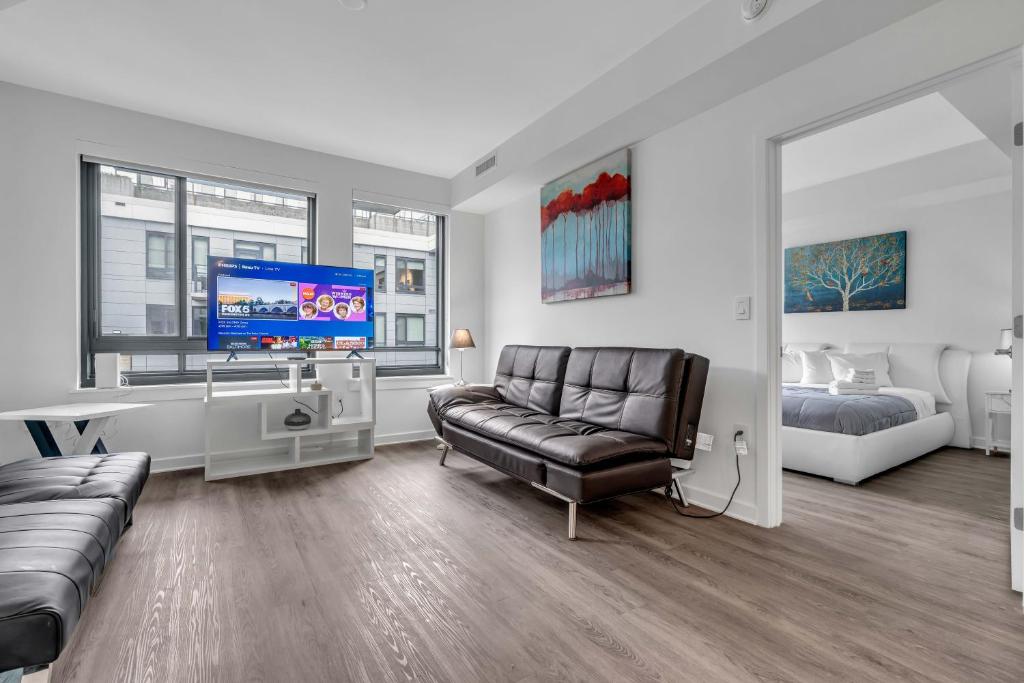 a living room with a couch and a tv and a bed at Two Bedroom Fully Furnished Apartment near Waterfront apts in Washington