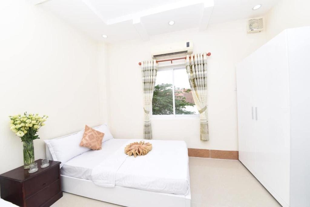 sala de estar blanca con sofá y ventana en Khách sạn Đồng Tháp - Hoàng Gia Minh Lợi en Mỹ An