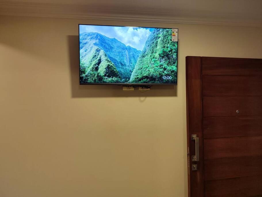 Elle comprend une télévision à écran plat suspendue au mur. dans l'établissement hermoso departamento confortable tribeca, à Cochabamba