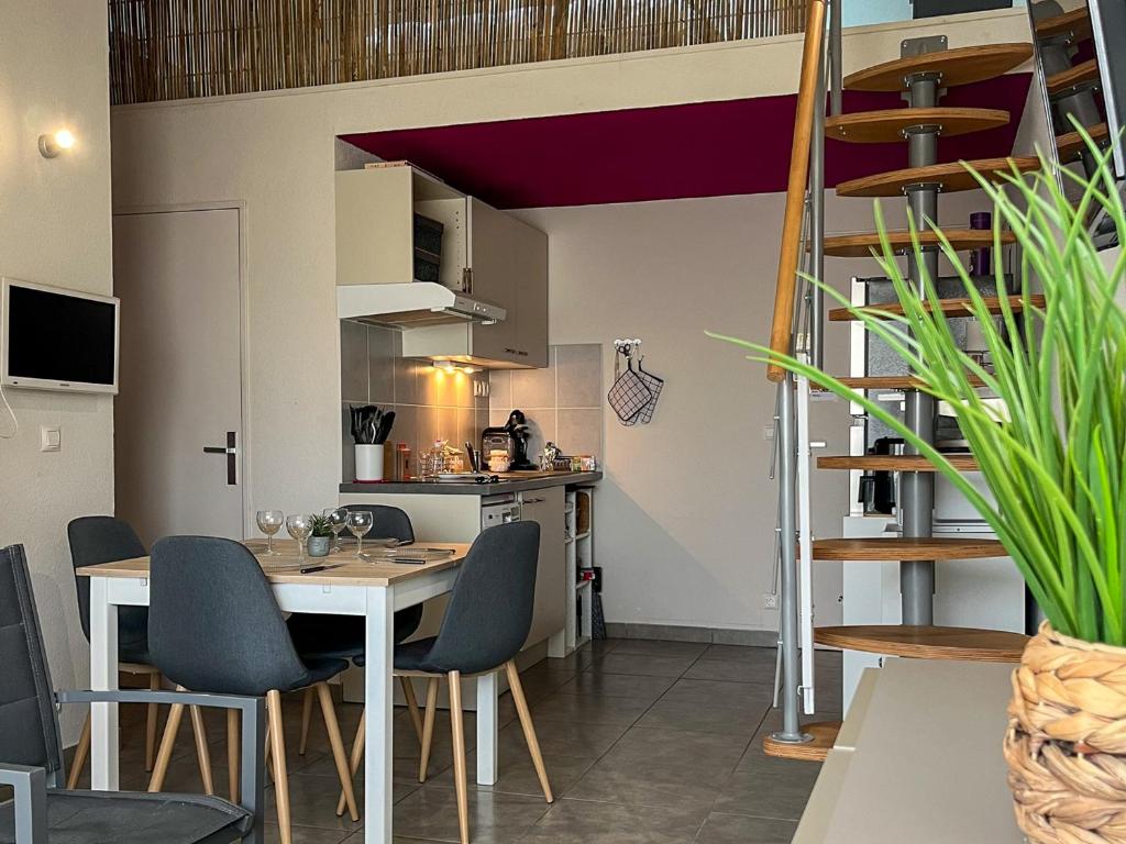une cuisine et une salle à manger avec une table et des chaises dans l'établissement Duplex convivial à Saint-Cyprien - 4 couchages - Plage & commerces à pied - FR-1-753-16, à Saint-Cyprien
