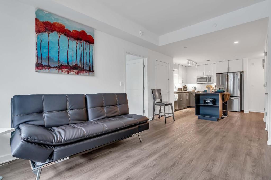 a living room with a leather couch and a kitchen at Waterfront 2BR Furnished Apartment apts in Washington, D.C.