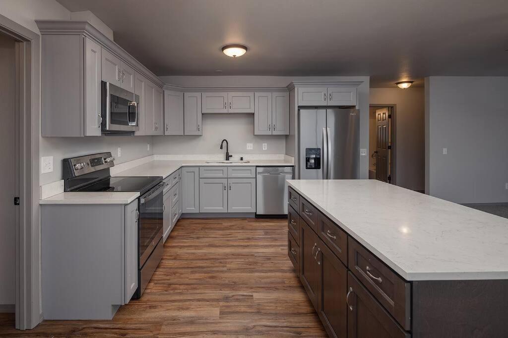 a kitchen with white cabinets and a white counter top at Top floor lakefront condo with Mountain Views! in Wasilla