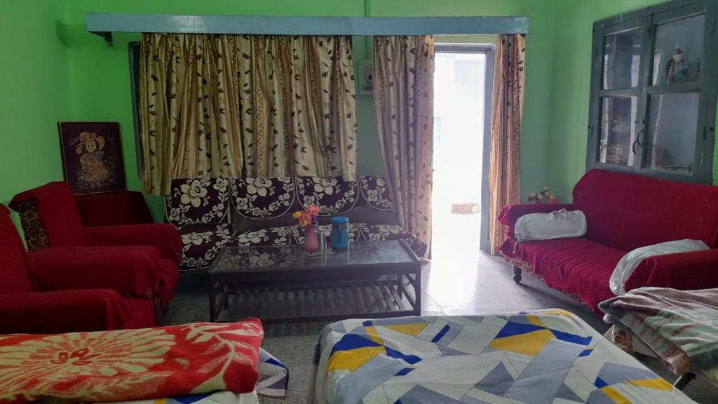 AyodhyaにあるKarunanidhan Homestaysのリビングルーム(ソファ、椅子2脚付)