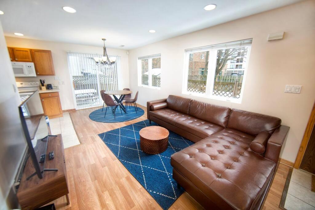 a living room with a leather couch and a blue rug at Tucked Away Off Brady - 4 Beds in Milwaukee