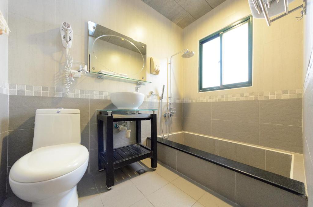 a bathroom with a toilet and a sink and a tub at 晶藍色美人魚 Mermaid Inn in Hualien City